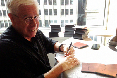 Bruce Cockburn signing the Rumours of Glory boxed set